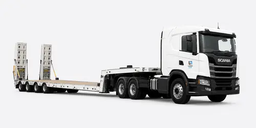 Low loader transporting an excavator